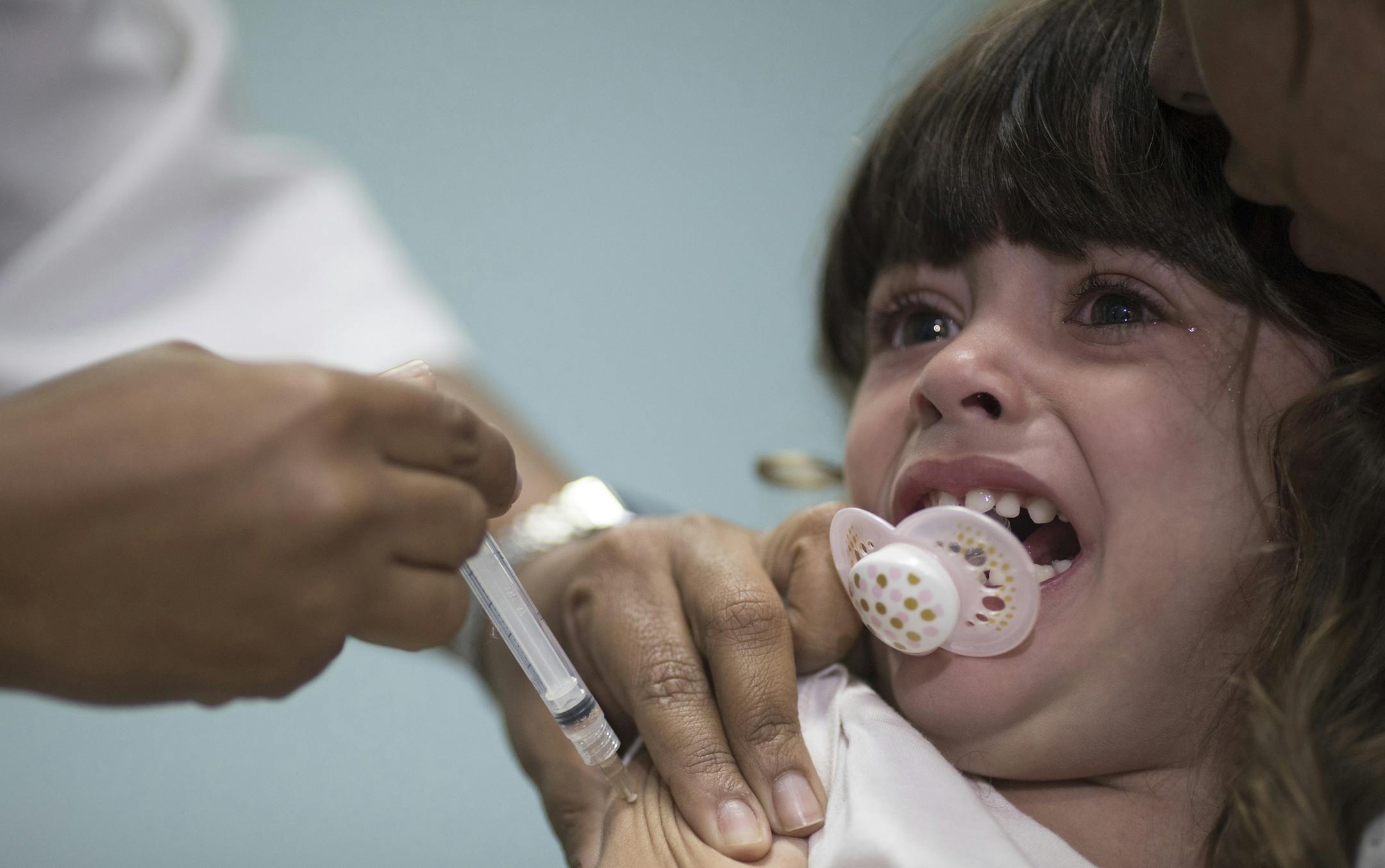 FILE - In this file photo dated Monday, Aug. 6, 2018, a child receives a measles vaccination in Rio de Janeiro, Brazil. The World Health Organization (WTO) said Monday Aug. 20, 2018, the number of measles cases in Europe jumped sharply during the first six months of 2018 with at least 37 people dead from the disease, and called for increased immunization rates to prevent an endemic. (AP Photo/Leo Correa, FILE)