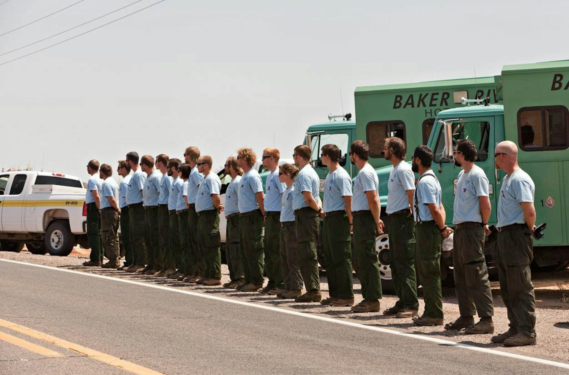 Members of the Baker River Hotshots from Sedro Wooley, Washington and Bureau of Land Management fire personnel lined Highway 89, by the BLM's Mohave Mountain Fire Center-north of Wickenburg, Ariz to honor the fallen members of the Granite Mountain Hotshot Crew as the bodies of the 19 firefighters were returned to Prescott, Ariz., Sunday, July 7, 2013 from Phoenix. All, save one, of the crew perished fighting the Yarnell Hill Fire on June 28, 2013.
