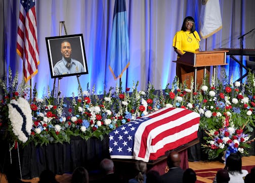 Pastor Mike Emmert, left, listens as Denise Raper, aunt of Minneapolis police Officer Jamal Mitchell, right, speaks during a public memorial service for Mitchell at Maple Grove Senior High School, Tuesday, June 11, 2024, in Maple Grove, Minn. Mitchell was shot and killed while responding to a shooting on May 30, 2024. (AP Photo/Abbie Parr, Pool)