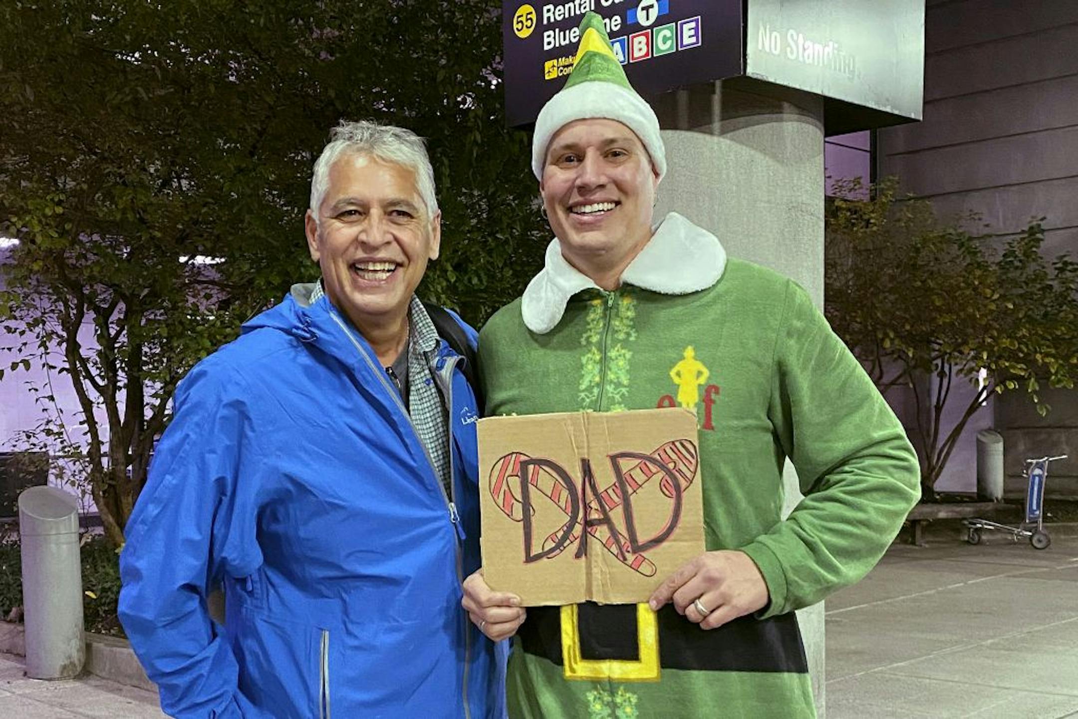 Doug Henning, right, who was adopted as a baby, poses with his biological father after meeting face to face for the first time on Tuesday, Nov. 24, 2020, at Logan International Airport in Boston. Henning, of Eliot, Maine, wore a costume like the one actor Will Ferrell's character wore in the movie "Elf" and he broke into the same awkward song from the movie while meeting his father.