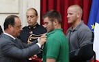 French President Francois Hollande, left, awards the Legion of Honor to Alek Skarlatos a U.S. National Guardsman from Roseburg, Oregon, while U.S. Air