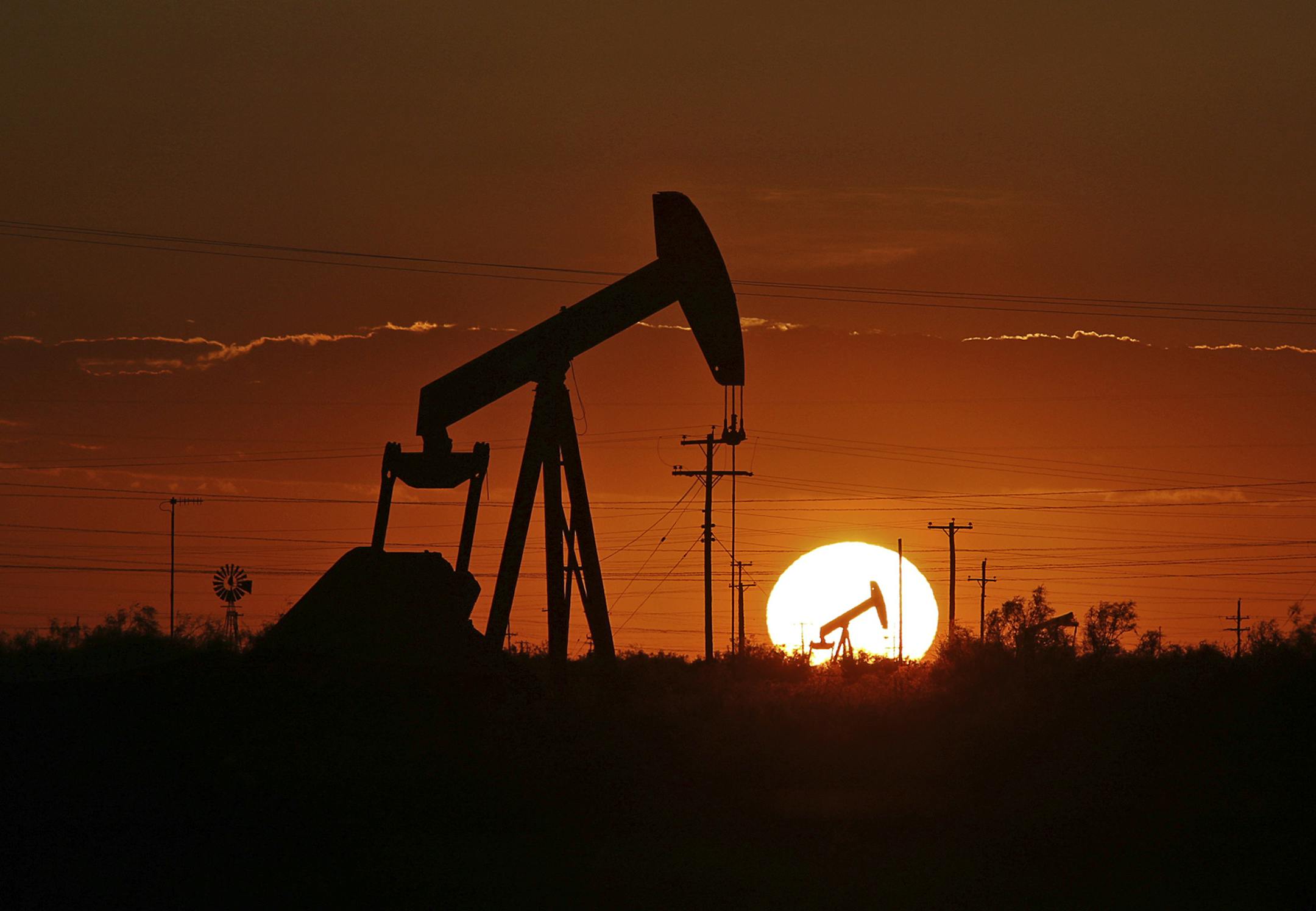FILE - In this June 11, 2019, file photo a pump jack operates in an oil field in the Permian Basin in Texas. New Mexico Democrats pushed forward a progressive agenda as the booming oil industry made headlines in 2019 with record revenues for the state's coffers. (Jacob Ford/Odessa American via AP, File)