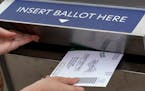 A voter inserted her absentee voter ballot into a drop box Oct. 15 in Troy, Mich.