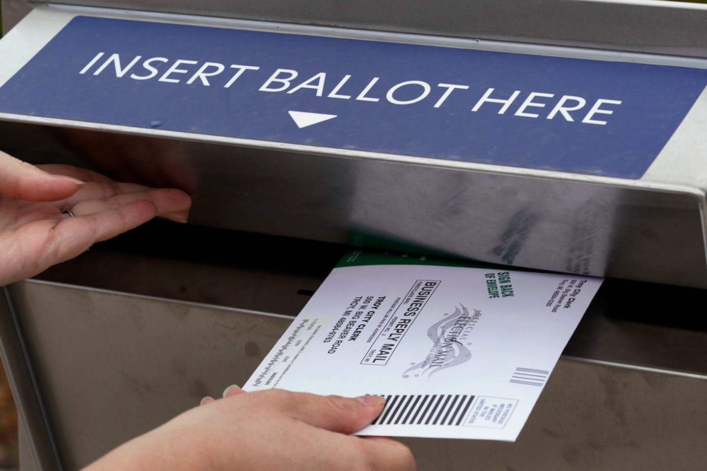 A voter inserted her absentee voter ballot into a drop box Oct. 15 in Troy, Mich.