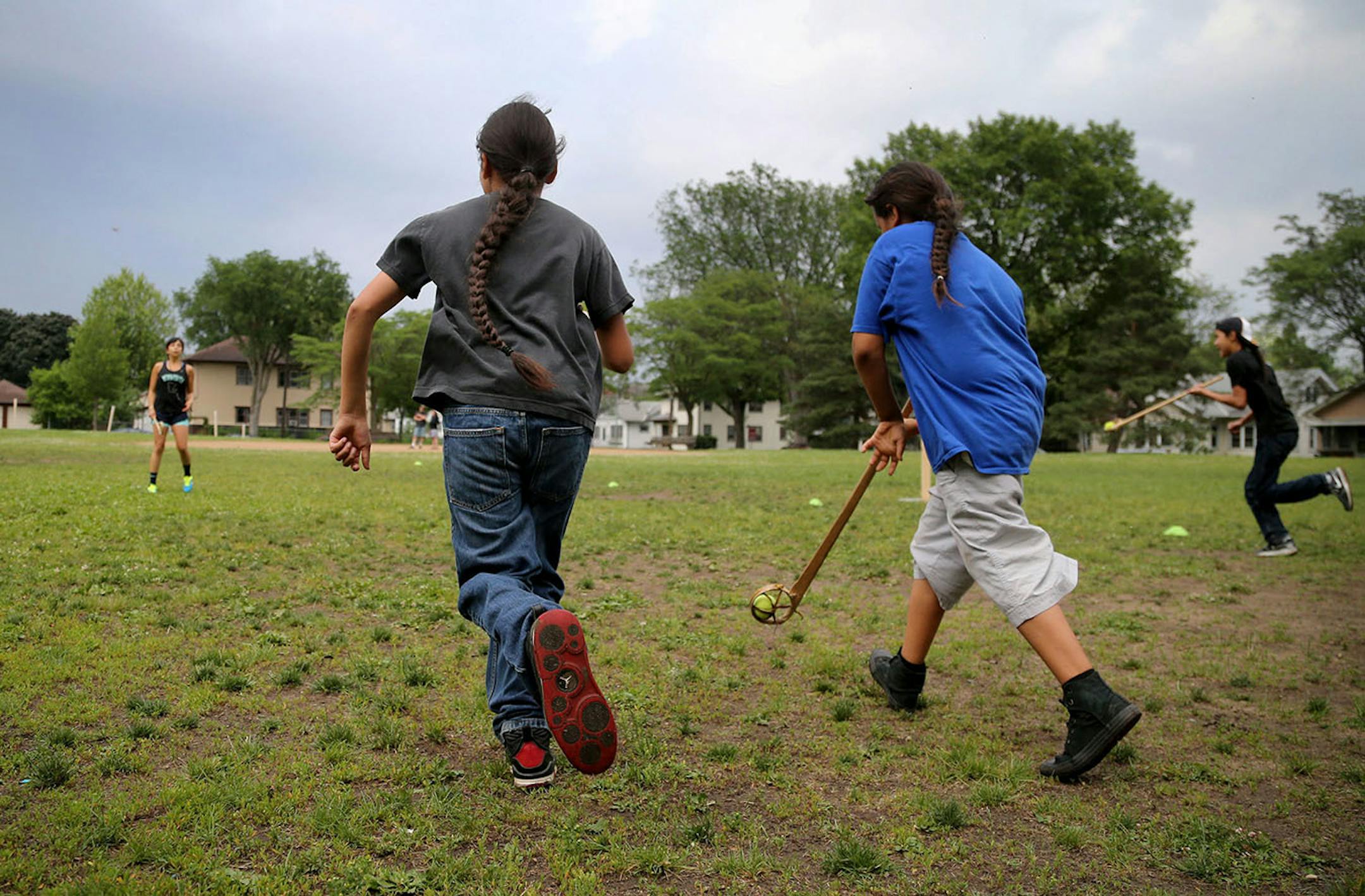 Youth boys team members of Twin Cities Native Lacrosse practice as one of their coaches Sasha Brown, top left, urges them on at Corcoran Park Wednesday, June 17, 2015, in Minneapolis, MN. The traditional Lacrosse players, who play with hand carved ash sticks, were preparing for the upcoming Twin Cities Native Lacrosse Tournament at the Osseo High School Saturday.