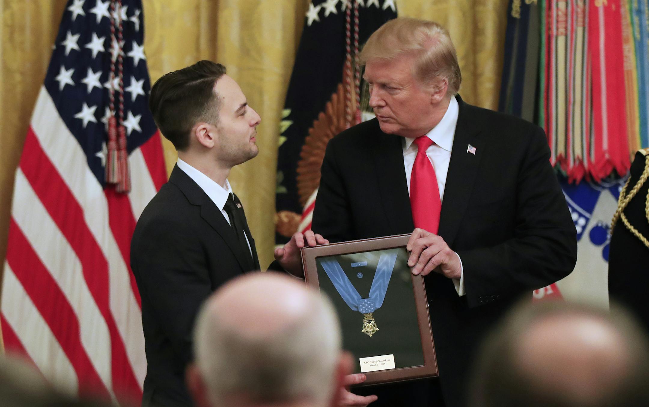 Trevor Oliver accepts the Medal of Honor from President Donald Trump, presented to his father, Army Staff Sgt. Travis Atkins in recognition for conspicuous gallantry in Iraq in June 2007, during a ceremony in the East Room of the White House, Wednesday March 27, 2019, in Washington.(AP Photo/Manuel Balce Ceneta)