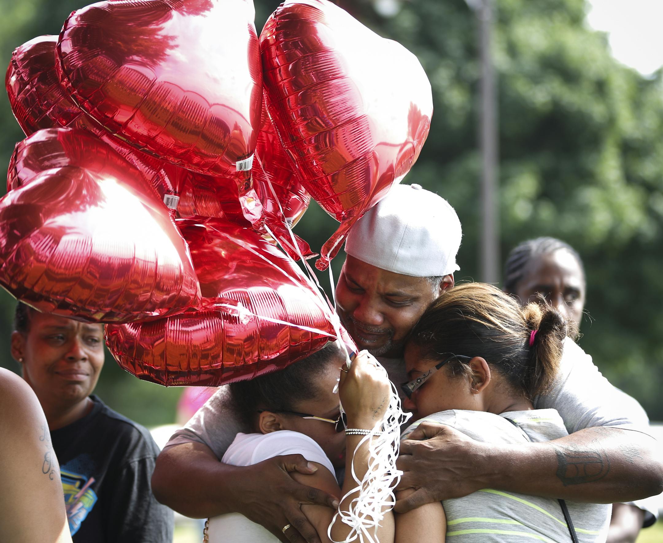 Sharrod Rowe, Sha-kim's father, hugged loved ones as they arrived with balloons to release in the air in Sha-Kym's memory during a memorial on Thursday, August 7, 2014 at the East beach at Lake Nokomis where 15-year-old Sha-Kym Adams drowned yesterday while at the beach with his friends. ] RENEE JONES SCHNEIDER • reneejones@startribune.com ORG XMIT: MIN1408071659143864
