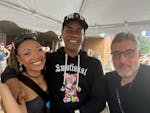 "Purple Rain" performer Holly Conway, music supervisor Jason Michael Webb and producer Orin Wolf smile under a tent at the Prince block party. Wolf br