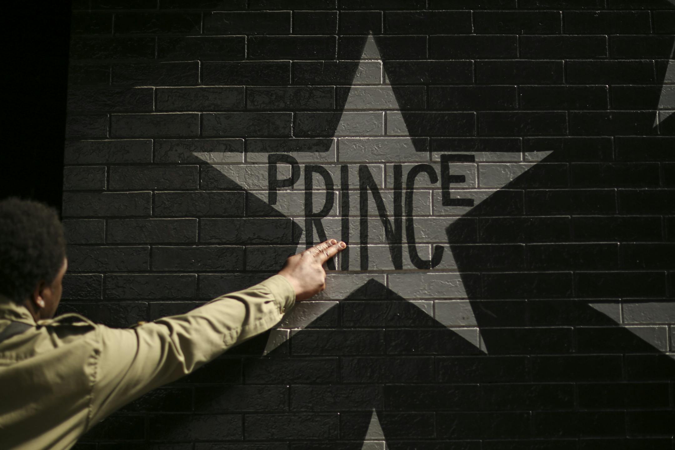 After kissing his fingers, a fan touched Prince's star on the wall of First Avenue. Tuesday afternoon.