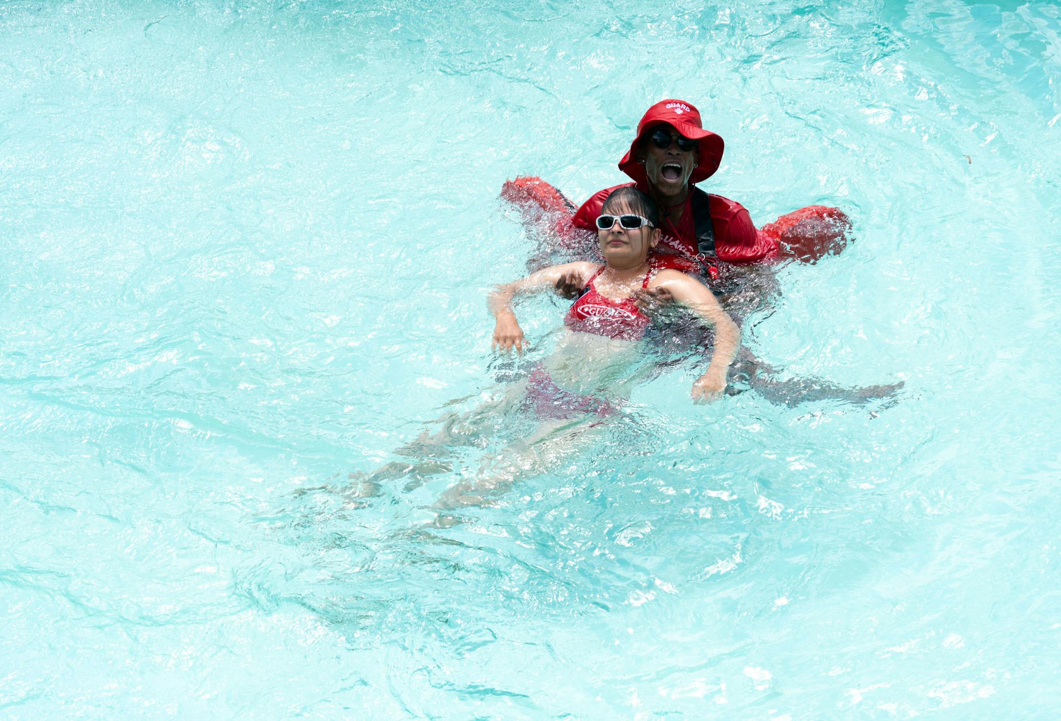 Lifeguard-in-training Elijah Stende helps the victim, Erika Bulau, out of the water during a training program for new Ramsey County lifeguards.
