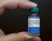 In this Thursday, Jan. 29, 2015 photo, pediatrician Charles Goodman holds a dose of the measles-mumps-rubella, or MMR, vaccine at his practice in Nort
