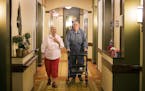 Right at Home caregiver Judy Trest walks with Howard Andrea, 78, to the laundry room inside his home in the Shores of Lake Phalen assisted living faci