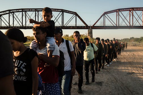 Migrants make their way toward law enforcement personnel to surrender and begin their immigration process, in Eagle Pass, Texas on Sept. 23, 2023.