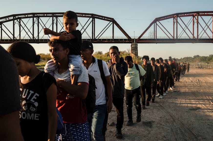 Migrants make their way toward law enforcement personnel to surrender and begin their immigration process, in Eagle Pass, Texas on Sept. 23, 2023.