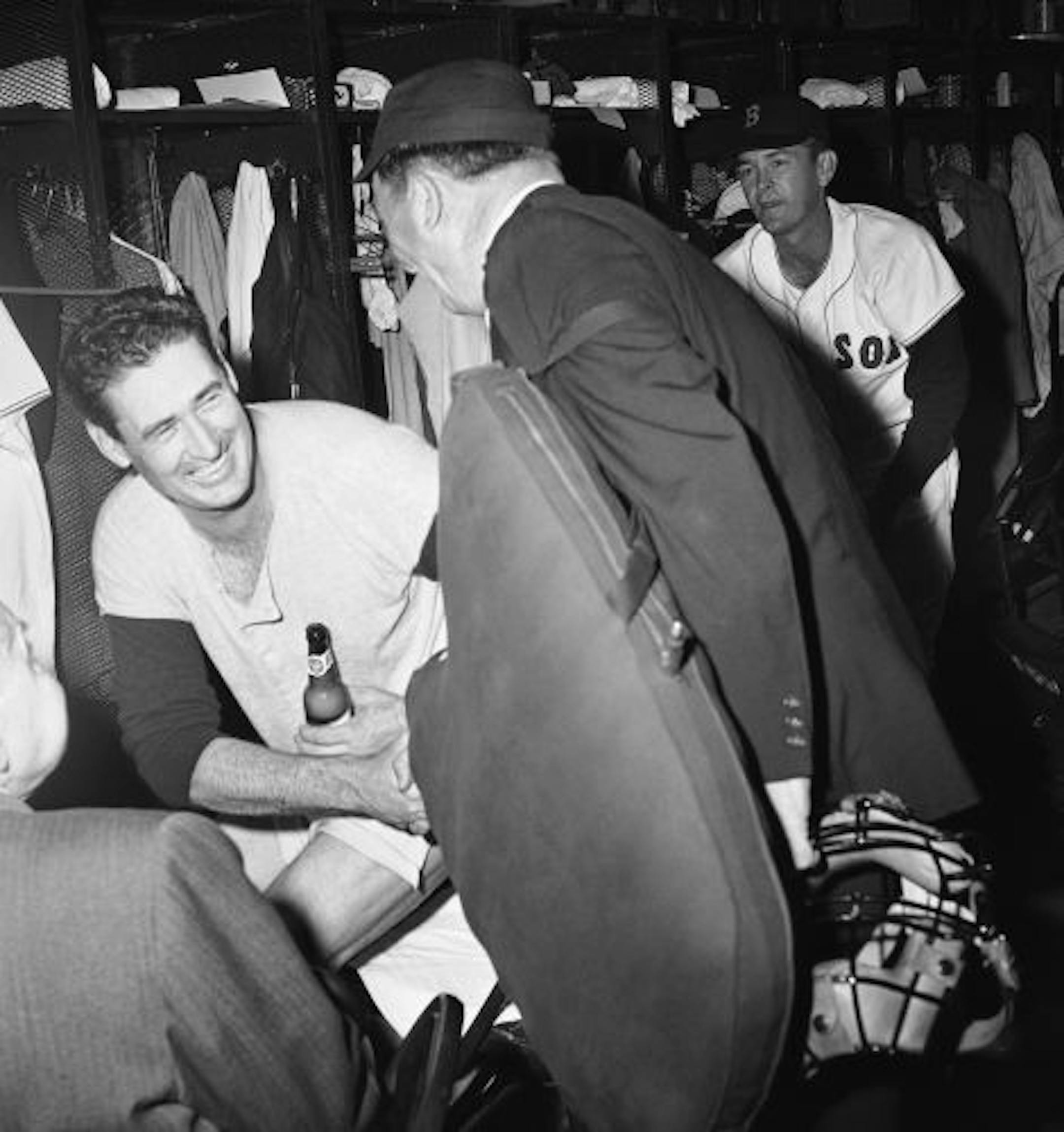 Umpire Ed Hurley congratulates Boston Red Sox slugger Ted Williams on his 521st home run of his career, in the dressing room at Fenway Park in Boston, Sept. 28, 1960. Williams hit the homer in the eighth inning of the game with Baltimore. At the end of the game Ted announced his immediate retirement.
