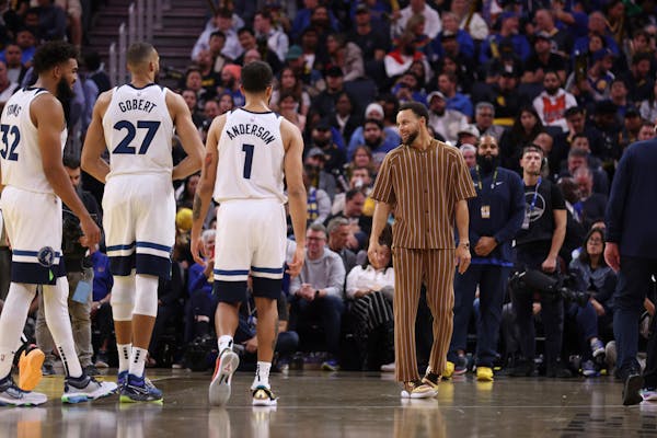 Golden State Warriors guard Stephen Curry, right, speaks with Minnesota Timberwolves center Karl-Anthony Towns (32), center Rudy Gobert (27) and forwa