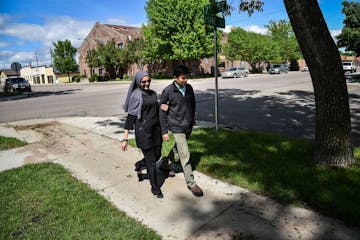 Dr. Ayaz Virji, 42, and his wife Musarrat Virji, 36, walks home from work on a May day in Dawson, Minn. MUST CREDIT: Washington Post photo by Salwan G