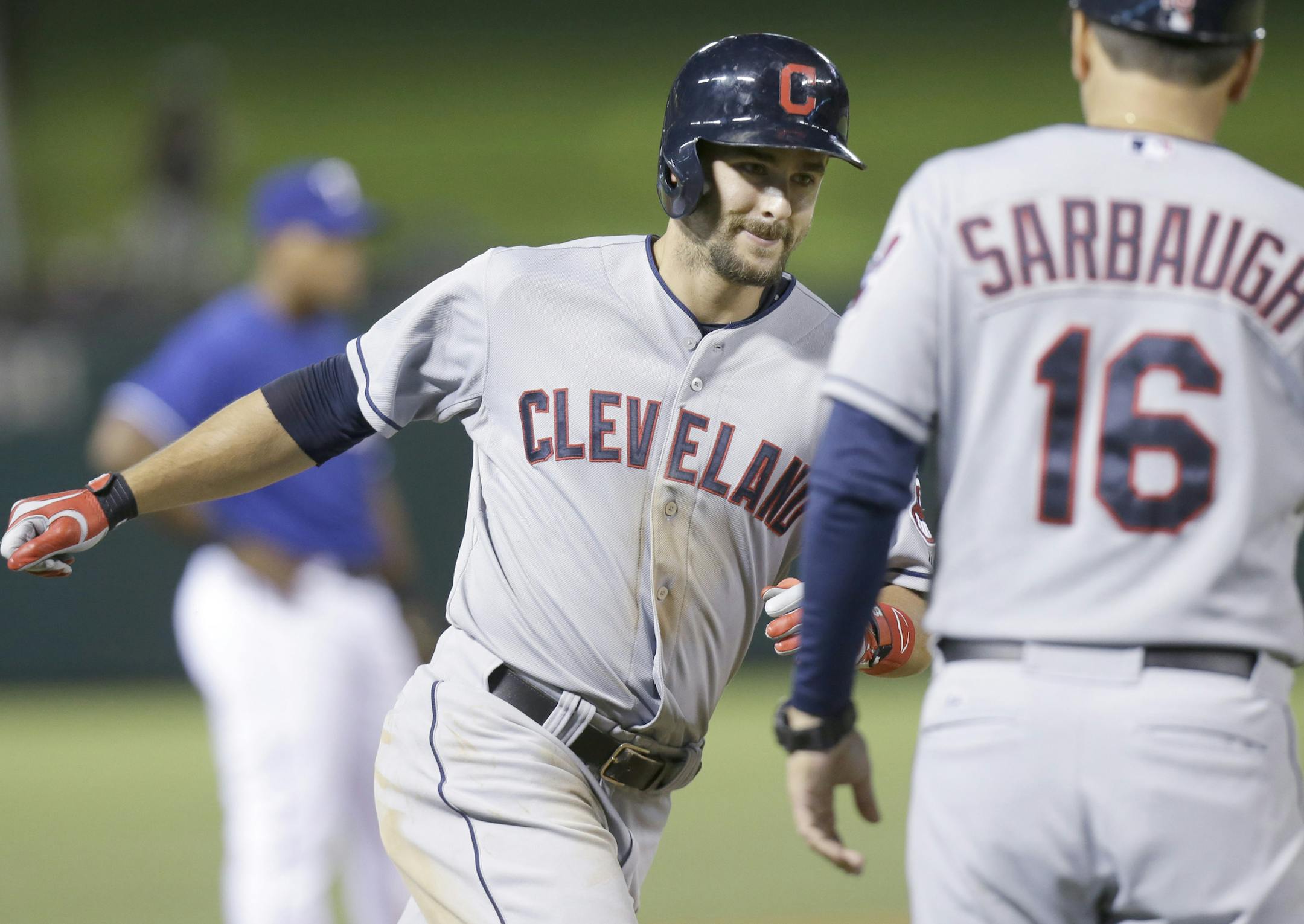 Cleveland Indians Lonnie Chisenhall, left, rounds the bases past third base coach Mike Sarbaugh (16) after hitting a three run homer during the eighth inning of a baseball game against the Texas Rangers in Arlington, Texas, Monday, June 9, 2014. (AP Photo/LM Otero)