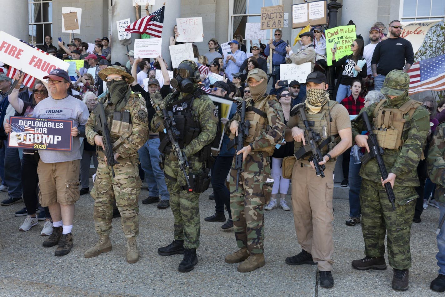 FILE - In this May 2, 2020, file photo, people, including those with the boogaloo movement, demonstrate against business closures due to concern about COVID-19, at the State House in Concord, N.H. Facebook says it is banning a "U.S.-based anti-government network" associated with the broader "boogaloo" movement, designating it as a dangerous organization similar to groups like ISIS and white supremacist groups and individuals already banned from its service. As part of the announcement, Tuesday,