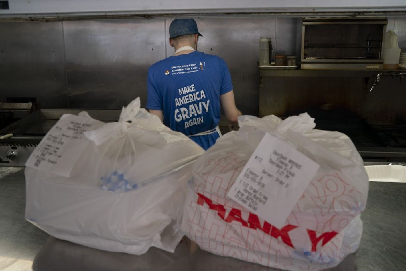 Joe Peterson, kitchen lead at the Nicollet Diner, tended to the grill making orders for takeout Tuesday afternoon.