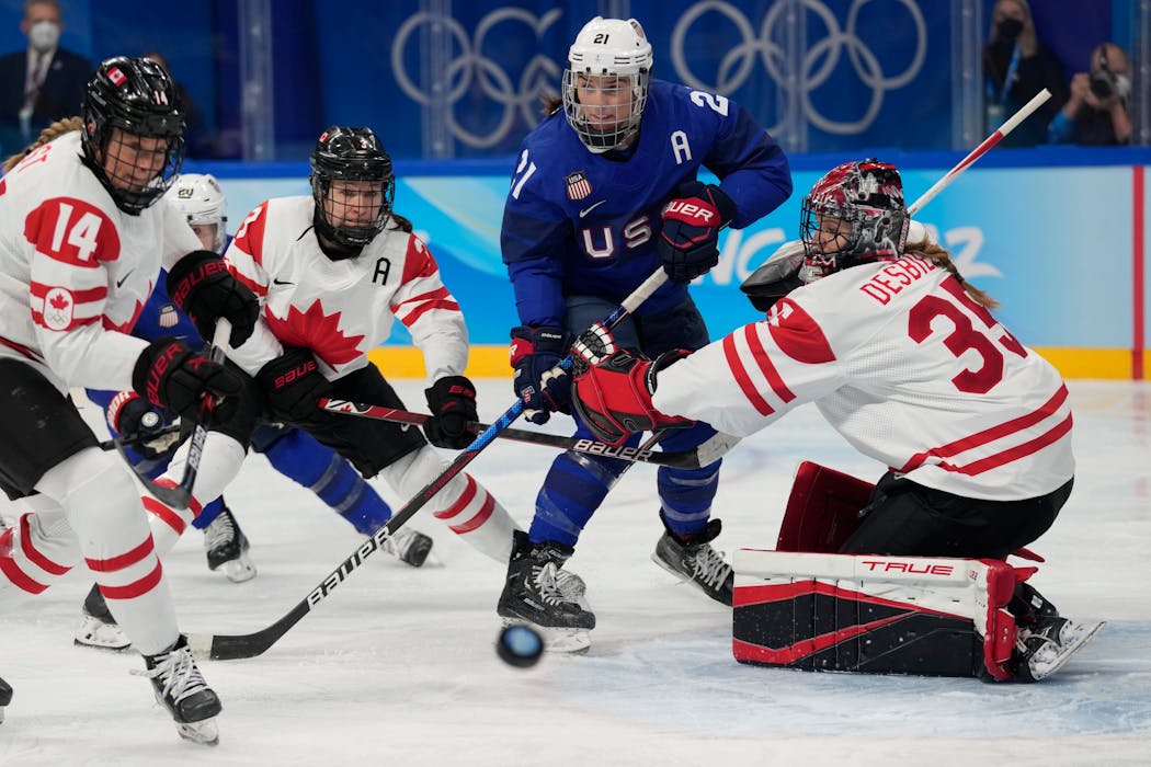 Canada goalkeeper Ann-Renee Desbiens (35) blocked a shot as Hilary Knight (21) watched for the rebound.