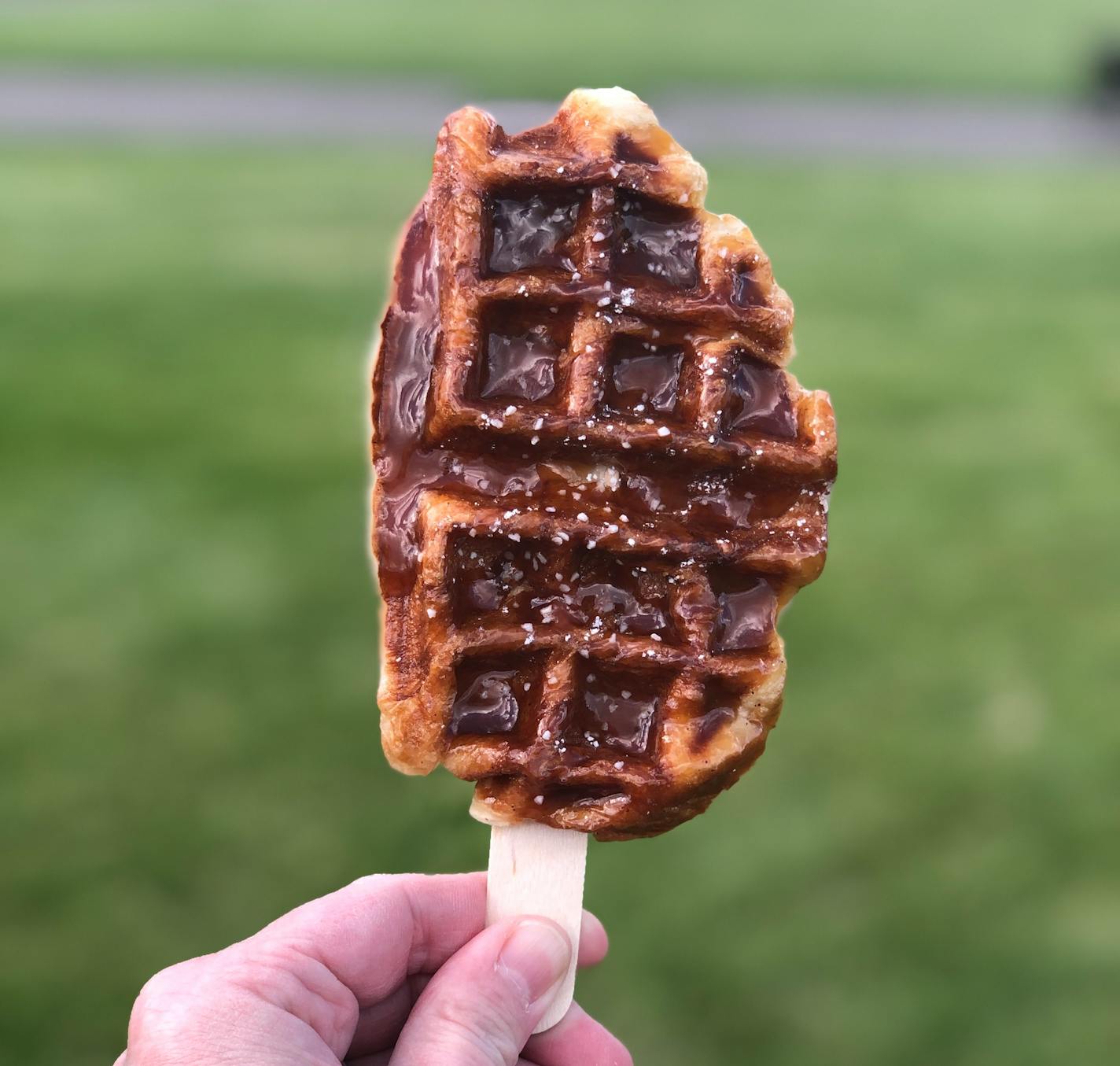 A croffle, which is a cross between a croissant and waffle, on a stick at a farmers market.