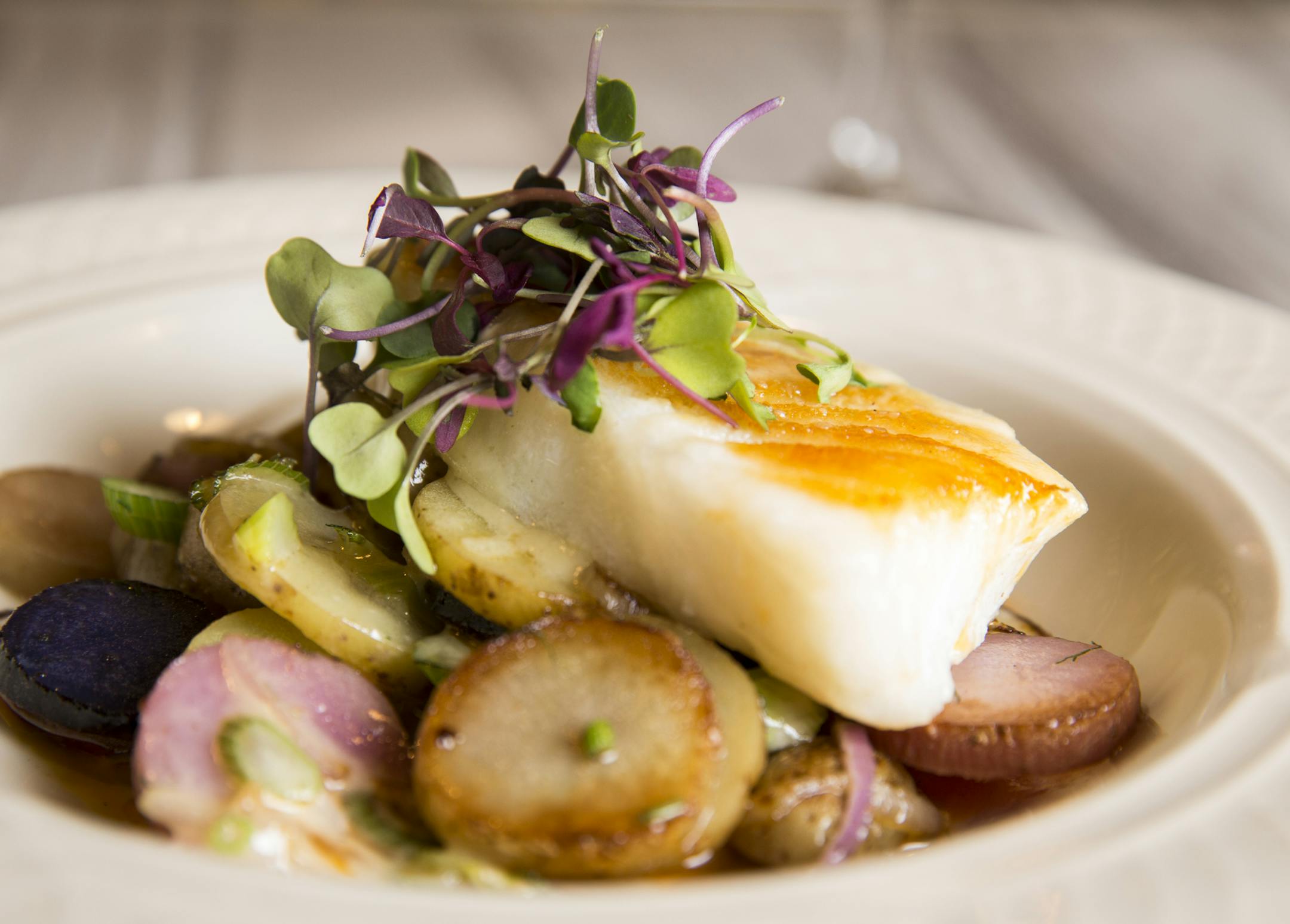 Pan-seared sea bass with brown butter, with lemony roasted potatoes and microgreens.