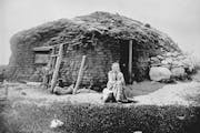 Norwegian immigrant Beret Hagebak in front of the sod home her family built in 1872 in western Minnesota. This photograph was taken in 1896.  