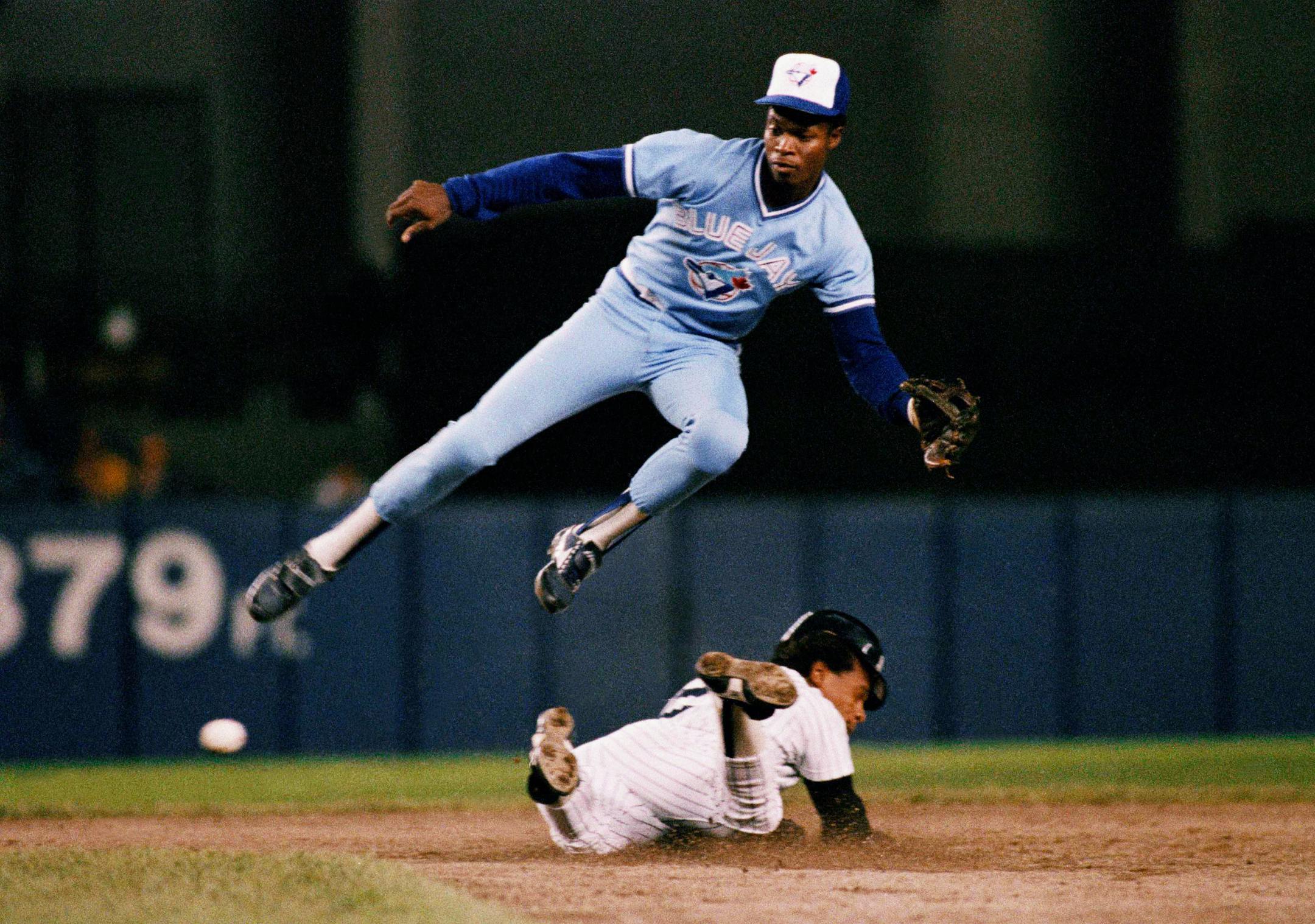 In this Sept. 18, 1987, file photo, the Yankees' Rickey Henderson, steals second base below Toronto shortstop Tony Fernández