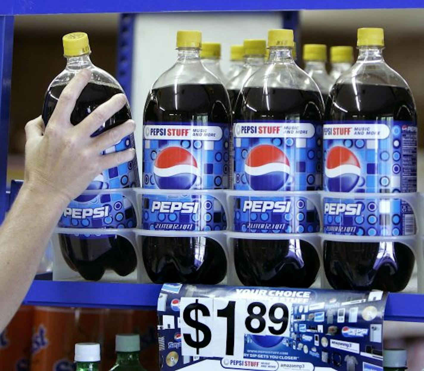 FDILE - In this April 21, 2008 file photo, a customer takes a bottle of Pepsi from a display at T & P Grocery in Hosford, Fla. Beverage and snack maker PepsiCo Inc. on Monday, April 20, 2009, offered to acquire its two largest bottlers _ Pepsi Bottling Group and PepsiAmericas _ for $6 billion in an effort to cut costs and become more efficient.