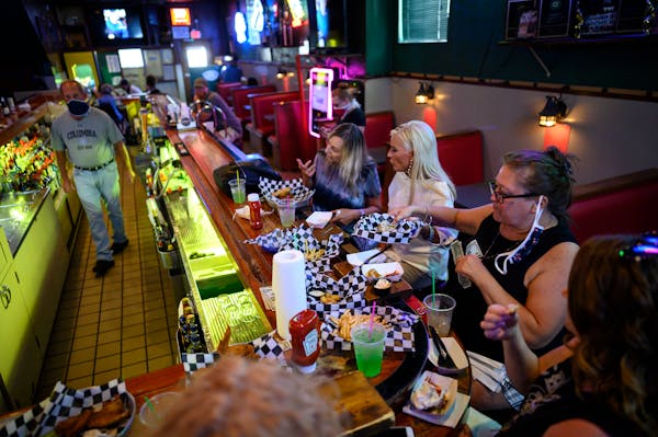 A group of regulars, mostly from Robbinsdale, drank and ate dinner at the bar Wednesday night at Tony Jaros River Garden. ]