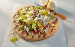 It's the best of both summer worlds: Chicken Caesar salad tops grilled flatbread. Food styling by Lisa Golden Schroeder.