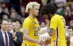 Minnesota's Jarvis Omersa (21) comforts Jordan Murphy (3) as the second half of a second round men's college basketball game against Michigan State co