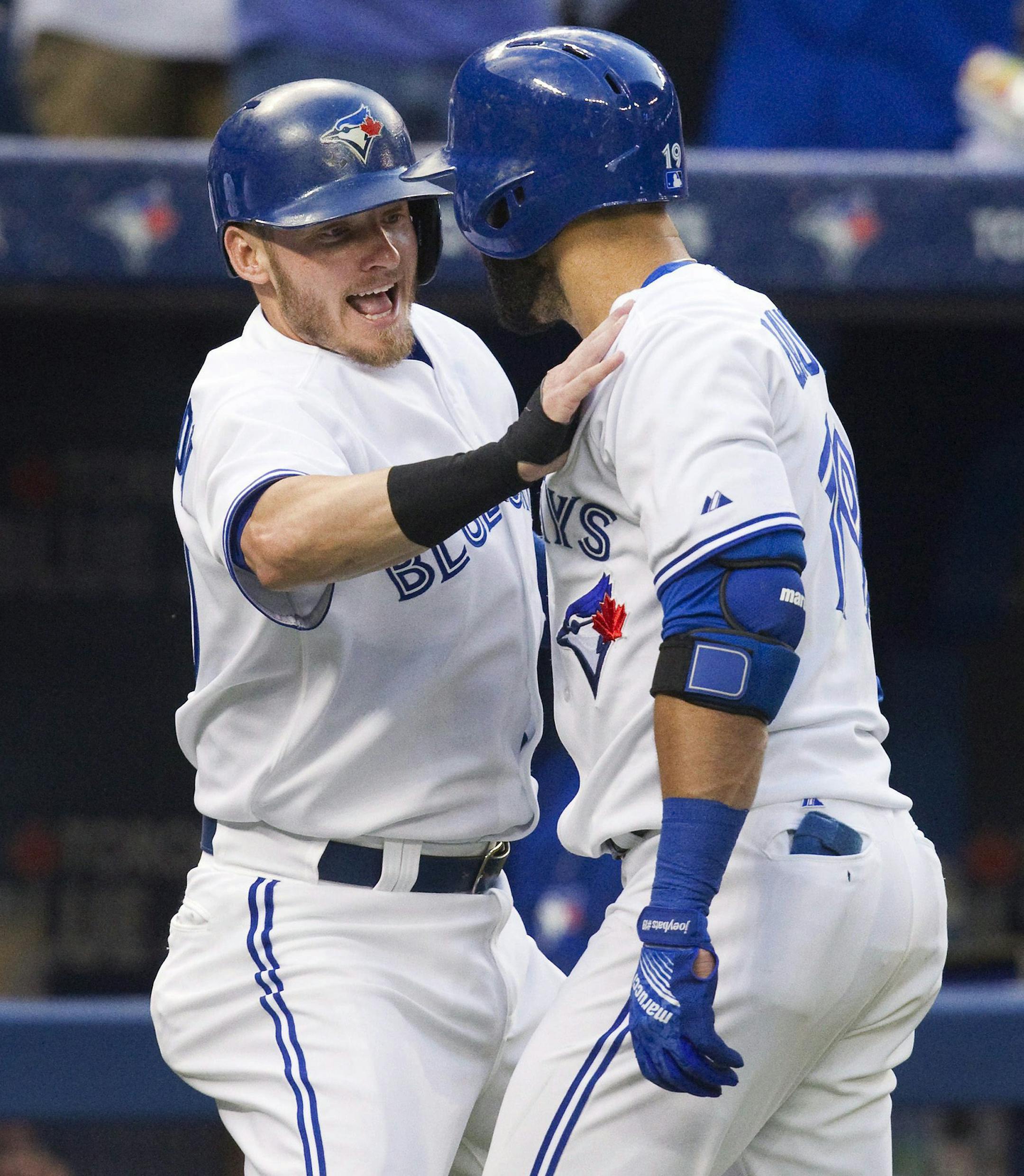 Toronto Blue Jays' Josh Donaldson, left, congratulates Jose Bautista after Bautista hit a grand slam against the Minnesota Twins during the second inning of a baseball game Wednesday, Aug. 5, 2015, in Toronto. (Fred Thornhill/The Canadian Press via AP)