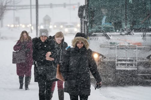 Commuters climbed out of busses and into the snow at the Apple Valley Transit station Monday afternoon. A winter storm was late in coming but hit the Twin Cities hard Monday afternoon.