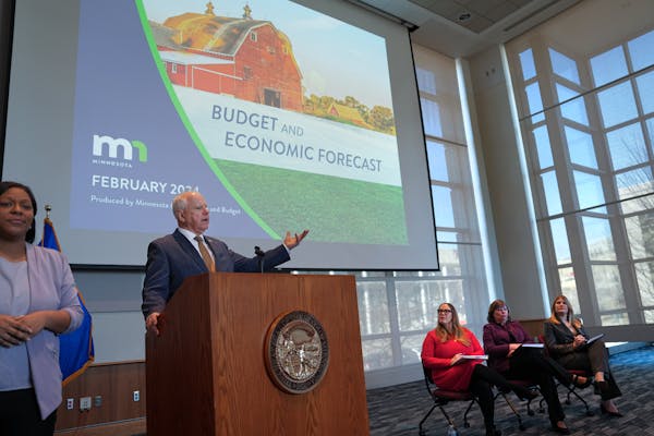 Gov. Tim Walz rected to the February budget forecast presented by on the right, MMB Commissioner Erin Campbell, State Economist Dr. Laura Kalambokidis