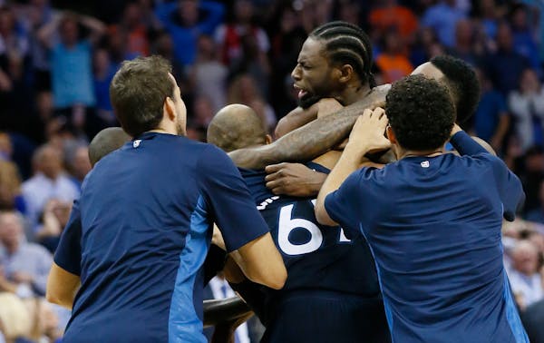 Minnesota Timberwolves guard Andrew Wiggins, center, is mobbed by his teammates after hitting the game winning shot at the buzzer in the fourth quarte