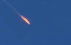 This frame grab from video by Haberturk TV, shows a Russian warplane on fire before crashing on a hill as seen from Hatay province, Turkey, Tuesday, N
