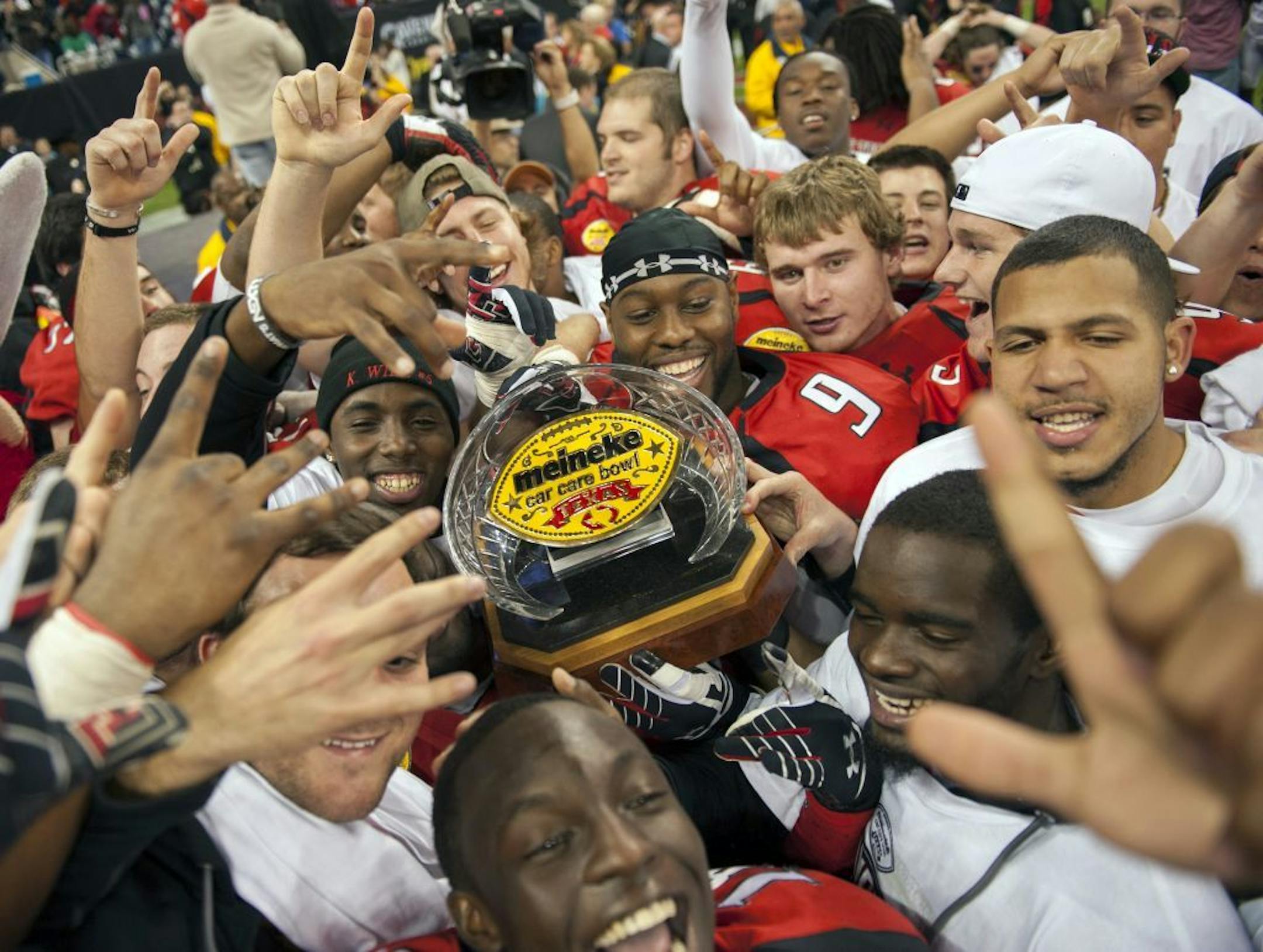 Texas Tech players celebrate with the championship trophy after winning the Meineke Car Care Bowl NCAA college football game against Minnesota, Friday, Dec. 28, 2012, in Houston. Texas Tech defeated Minnesota 34-31.