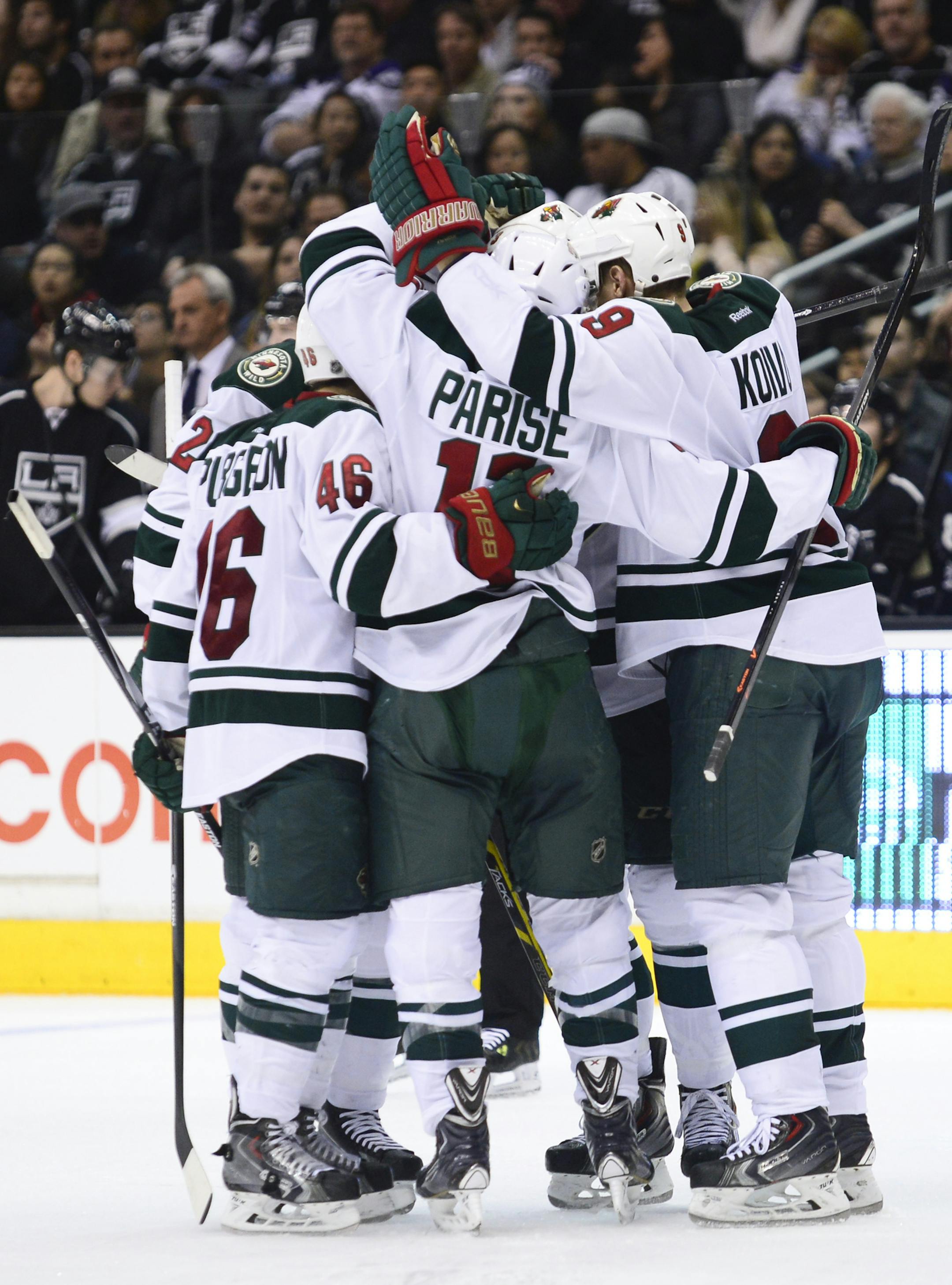 Minnesota Wild left wing Jason Zucker (16), left wing Zach Parise, center front, celebrate Minnesota Wild center Mikko Koivu's, right, Finland, goal along with the rest of the team during the third period of an NHL hockey game against the Los Angeles Kings, Monday, March 31, 2014, in Los Angeles. The Wild won 3-2.(AP Photo/Gus Ruelas)