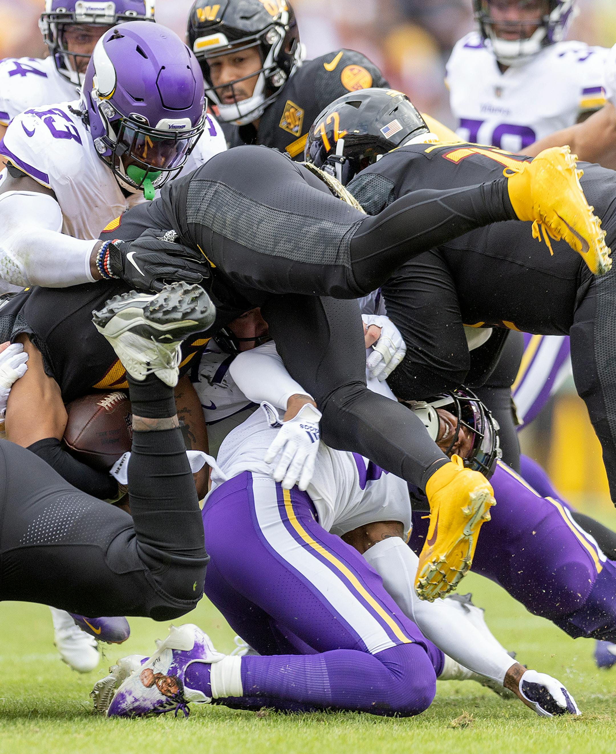 Vikings cornerback Cameron Dantzler Sr. (3) gets caught up under a pile and was given a penalty before he left the field with an injury in the second quarter.