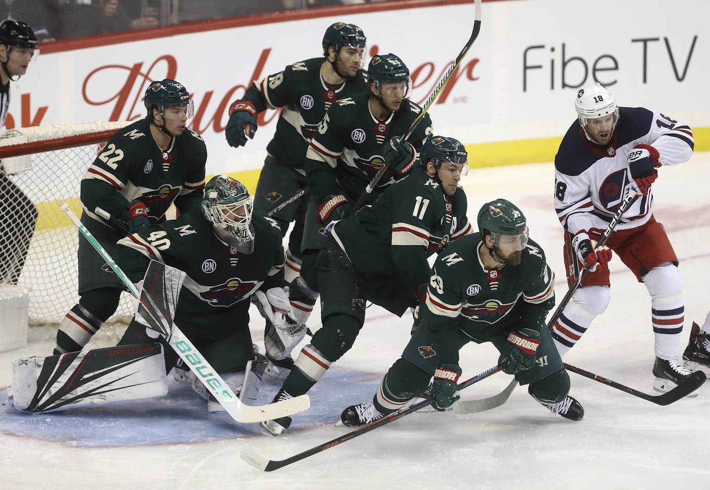 Minnesota Wild's Kevin Fiala (22), goaltender Devan Dubnyk (40), Luke Kunin (19), Jonas Brodin (25), Zach Parise (11) and Greg Pateryn (29) gather in front of the net as Winnipeg Jets' Bryan Little (18) looks for the puck during the first period of an NHL hockey game Tuesday, Feb. 26, 2019, in Winnipeg, Manitoba. (Trevor Hagan/The Canadian Press via AP)