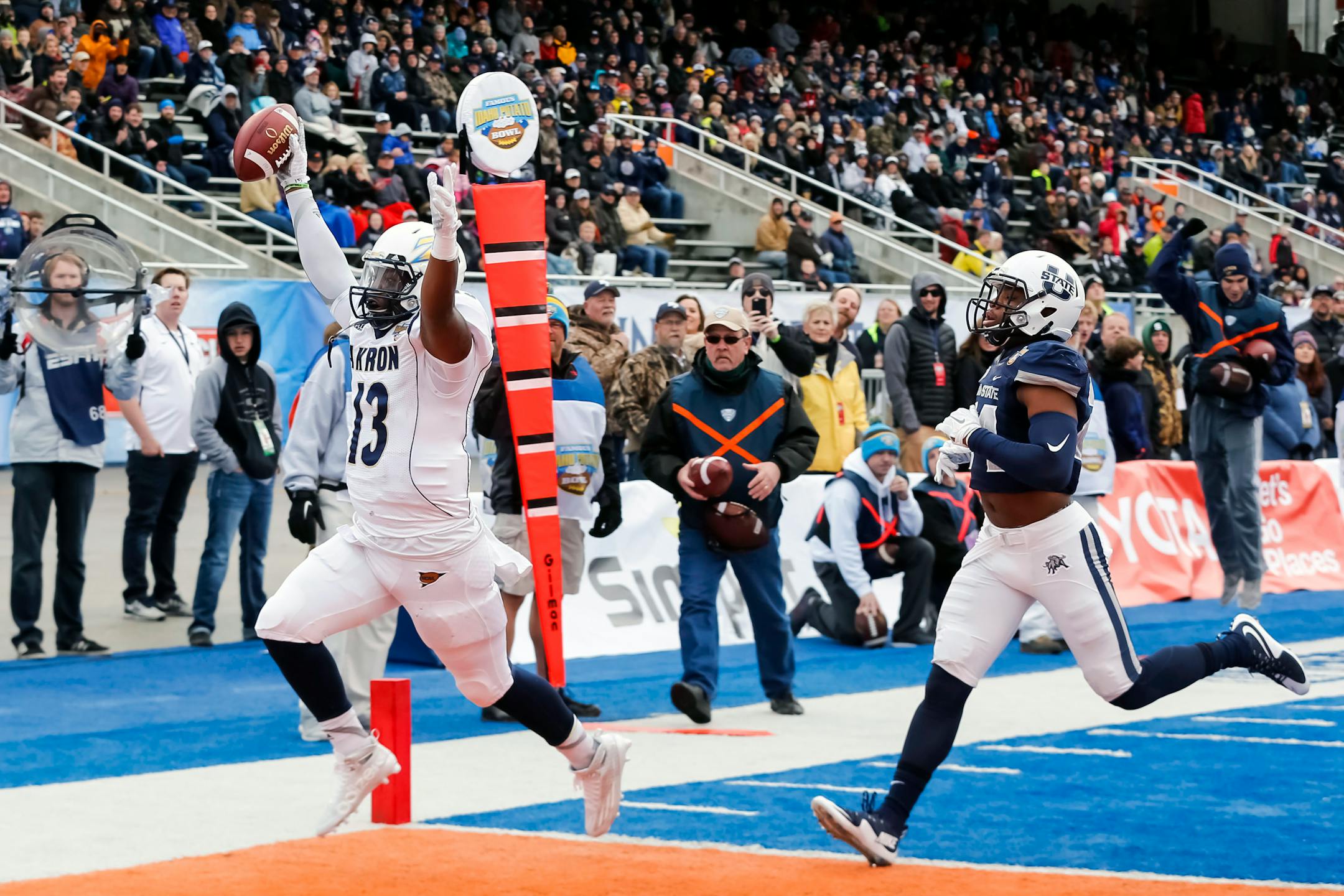 Akron quarterback Thomas Woodson (13) scored a touchdown during the first half of the Potato Bowl against Utah State in Boise, Idaho, on Tuesday.