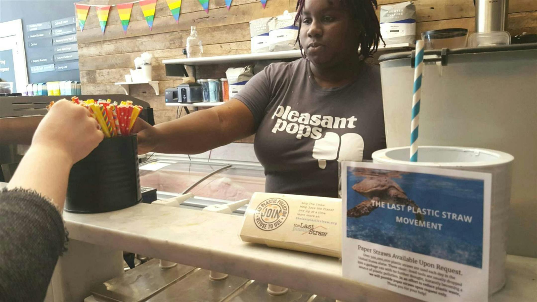 Nadia Bartholomew, a worker at Pleasant Pops coffee and treats shop in Washington, D.C., offers a customer a selection of paper straws. Pleasant Pops has joined the "Last Plastic Straw" movement, a growing number of restaurants no longer using plastic straws, which environmentalists say are hazardous to oceans and sea creatures. States and cities are being asked to ban straws, too. (Elaine S. Povich/Pew Charitable Trusts/TNS)