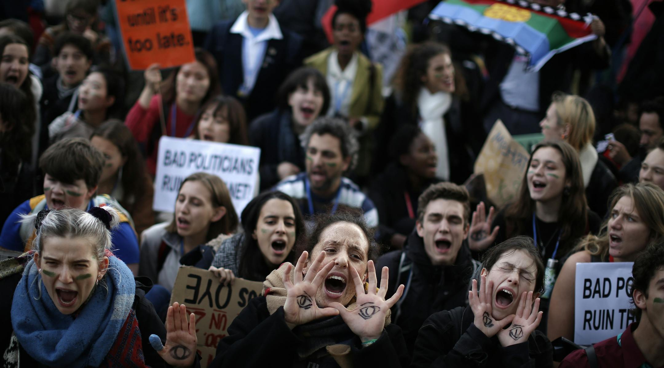 People shout slogans during a march organized by the Fridays for Future international movement of school students outside of the COP25 climate talks congress in Madrid, Spain, Friday, Dec. 13, 2019. The United Nations Secretary-General has warned that failure to tackle global warming could result in economic disaster. (AP Photo/Manu Fernandez)