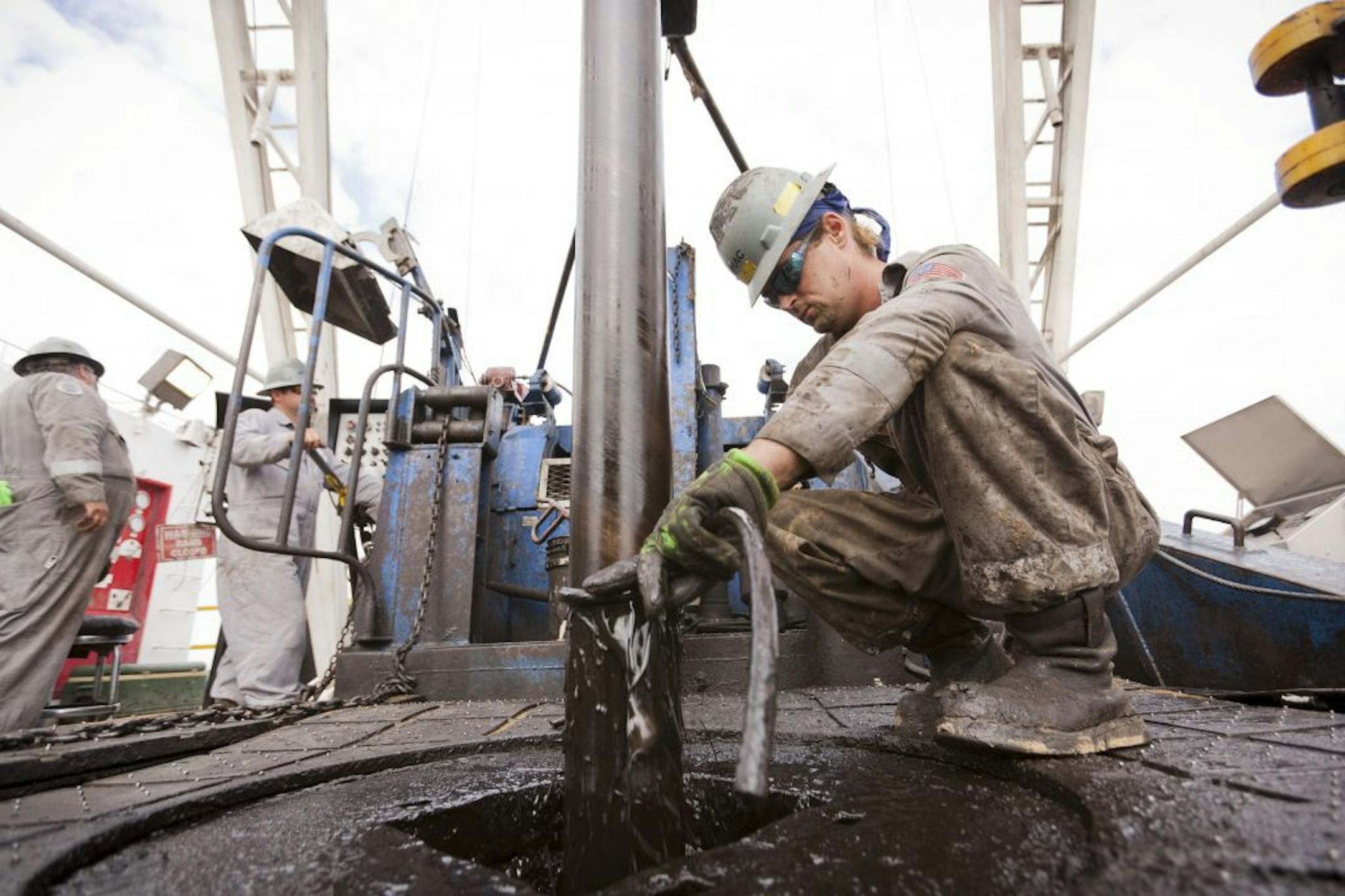 A Chesapeake Energy worker cleans oil from a pipe pulled from the ground at company's drilling site near Big Wells, Texas, May 17, 2011. Advocates of extracting oil from tightly packed rock, or the technique known as fracking, say it could increase the nation's oil output by 25 percent but opponents point to the risk to water supplies it creates.