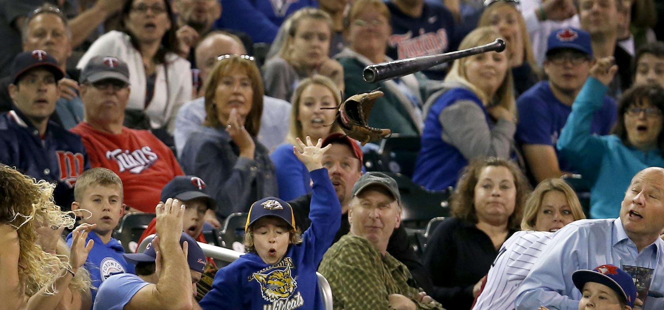 Fans attempted to avoid a loose bat that flew out of the hands of Edwin Encarnacion in the ninth inning during the Twins loss.