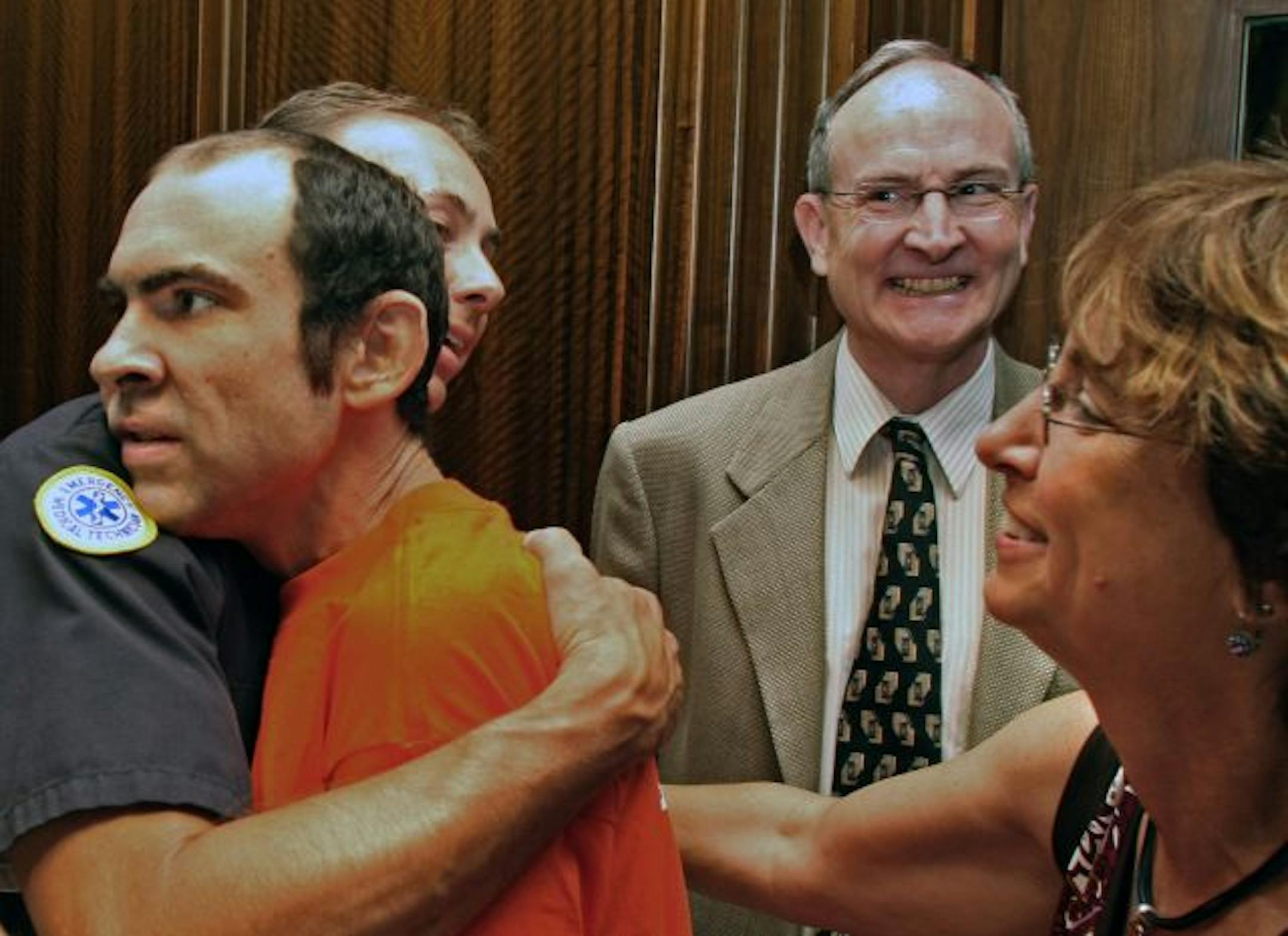 A hug from a rescuer: Keith Kennedy got a hug from St. Paul firefighter Gary Ruiz, one of the rescuers who found the 25-year-old autistic man after he was lost in dense Wisconsin woods. Watching were Kennedy's parents, Bruce and Linda Kennedy.