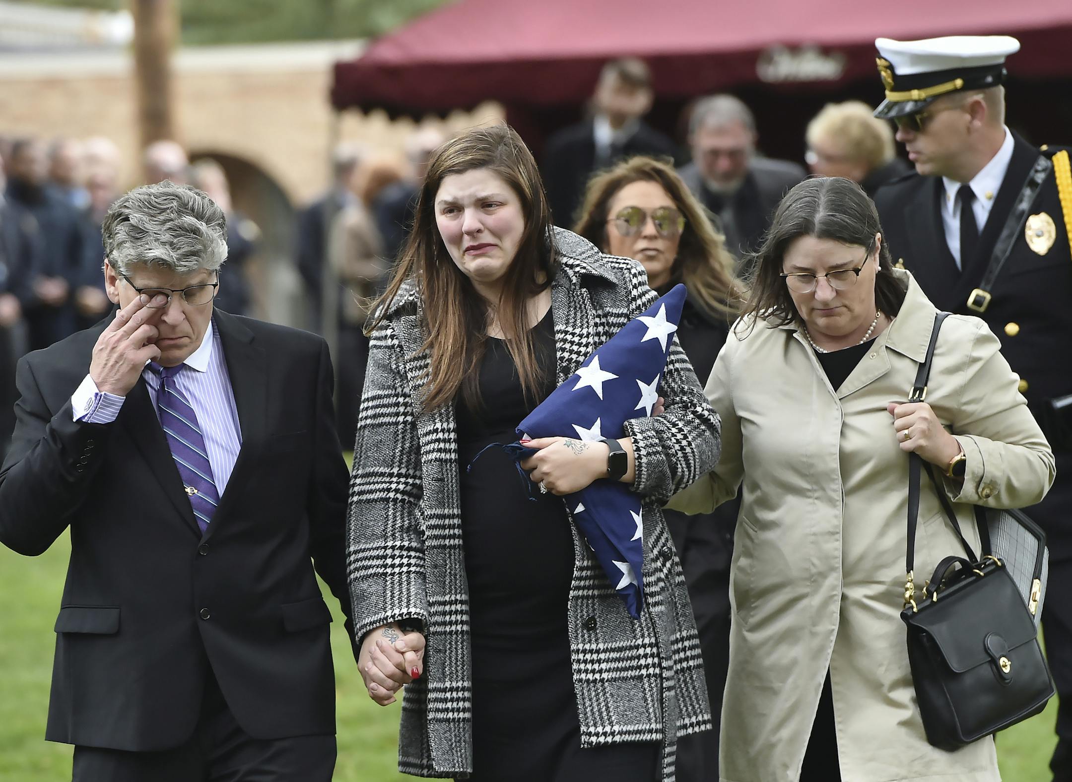 Andrea Parise, center, widow of corrections officer Joseph Parise, leaves his graveside services at Fairview Cemetery in Stillwater, Minn., on Tuesday, Oct. 2, 2018. With Parise are her parents, Mike and Nancy Dean. Parise died of a medical emergency last week after rushing to the aid of a fellow officer who was being attacked by an inmate at the Oak Park Heights maximum-security prison. Parise collapsed shortly after returning to his post and later died at Regions Hospital. (John Autey /Pioneer