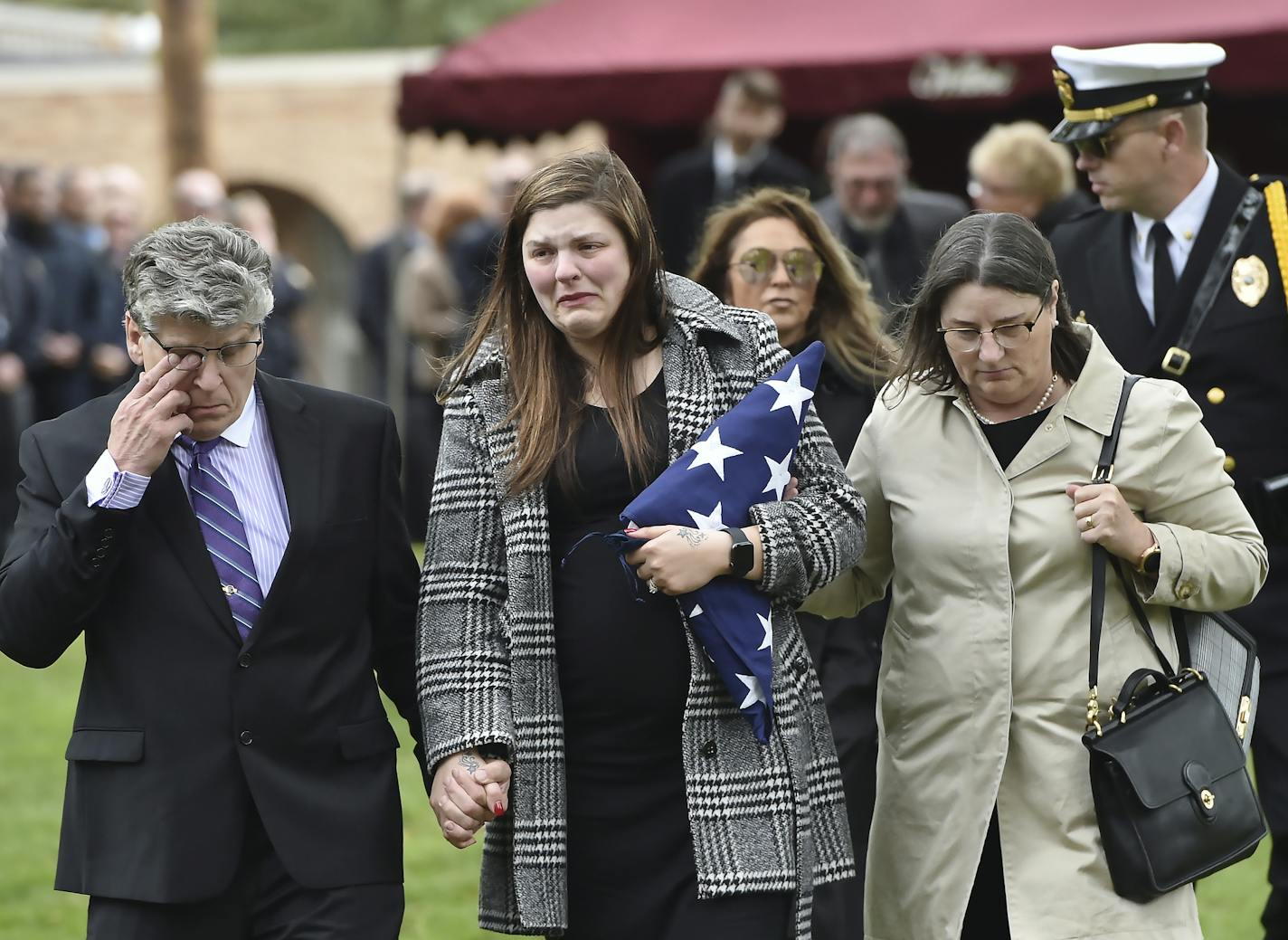 Andrea Parise, center, widow of corrections officer Joseph Parise, leaves his graveside services at Fairview Cemetery in Stillwater, Minn., on Tuesday, Oct. 2, 2018. With Parise are her parents, Mike and Nancy Dean. Parise died of a medical emergency last week after rushing to the aid of a fellow officer who was being attacked by an inmate at the Oak Park Heights maximum-security prison. Parise collapsed shortly after returning to his post and later died at Regions Hospital. (John Autey /Pioneer